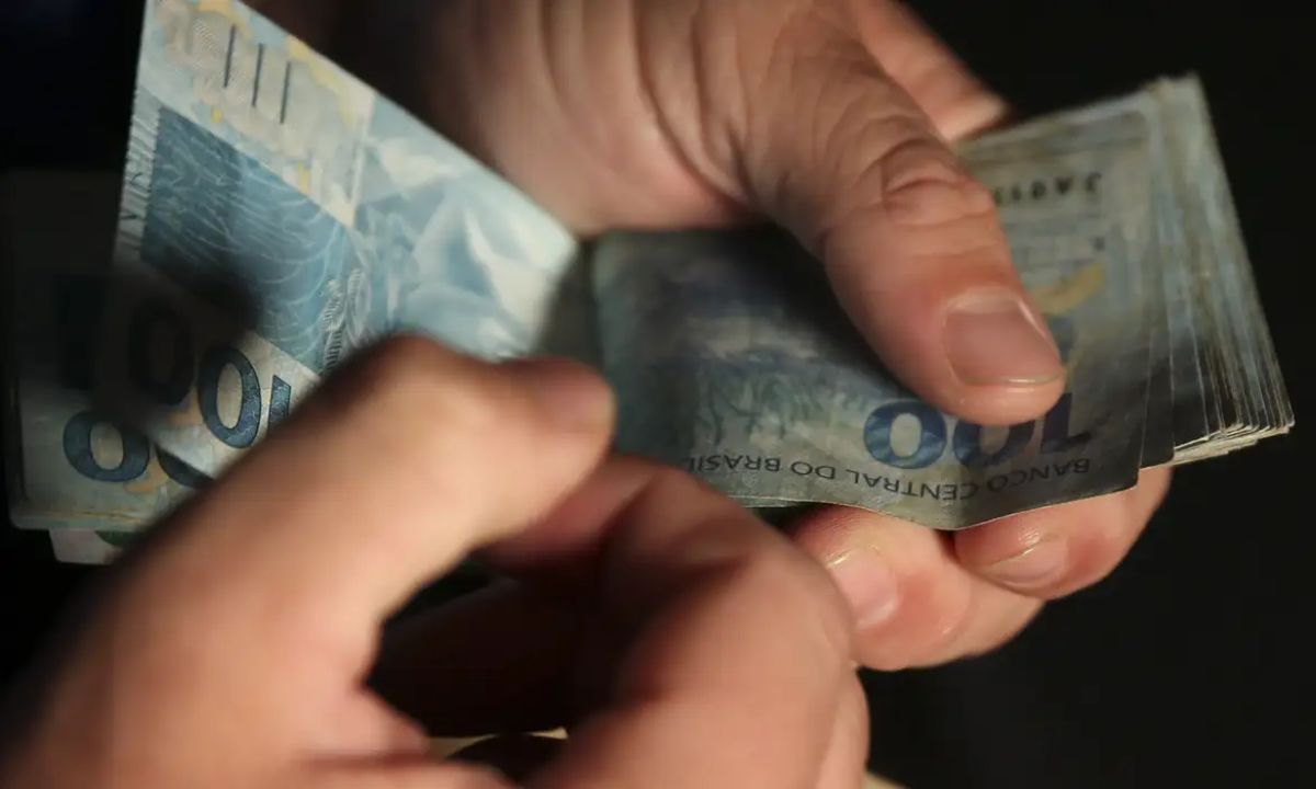 Homem conta cédulas de dinheiro